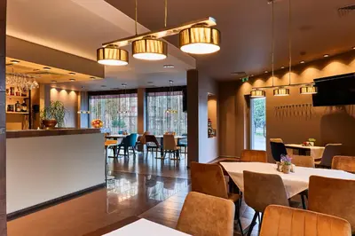 a restaurant with tables and chairs and a bar at Monet Hotel in Plovdiv