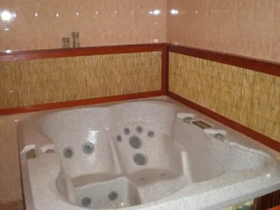 a bath tub in a bathroom with a tiled wall at The Castle Complex in Pamporovo