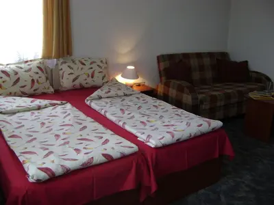 a hotel room with two beds and a chair at Michel Hotel in Bansko