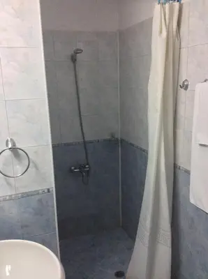 a shower with a shower curtain in a bathroom at Michel Hotel in Bansko