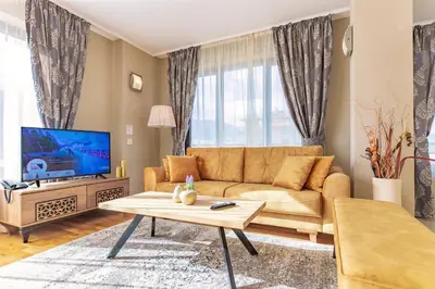 a living room with a couch and a tv at Murite Park Hotel in Bansko