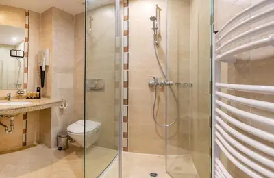 a bathroom with a shower with a toilet and a sink at Murite Park Hotel in Bansko