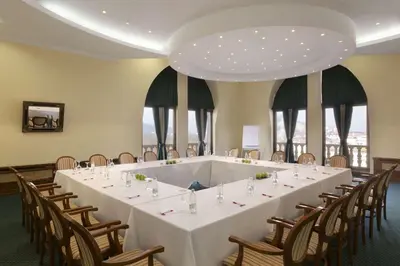 a long white table in a room with chairs at Ramada by Wyndham Plovdiv Trimontium in Plovdiv