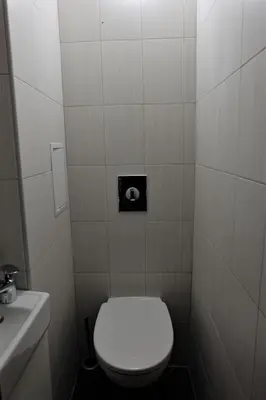 a bathroom with a white toilet and a sink at Best Choice Apartment in Sofia