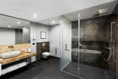 a bathroom with a shower and a sink and a toilet at InterContinental Sofia by IHG in Sofia