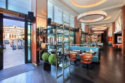 a lobby of a restaurant with a bar with stools at InterContinental Sofia by IHG in Sofia