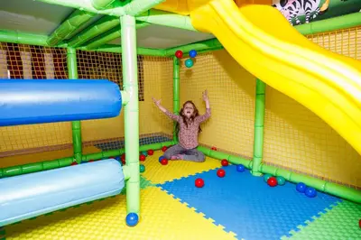 a little girl sitting in a play room with a slide at Spa Hotel Aspa Vila in Banya