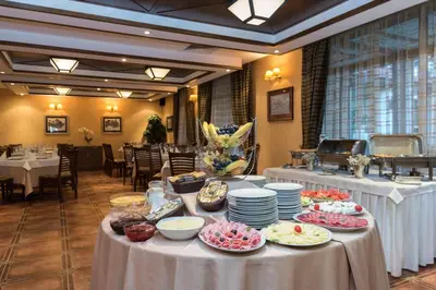 a table with plates of food on it in a restaurant at Evelina Palace Hotel in Bansko