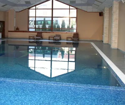 a pool with chairs and a reflection in the water at Evelina Palace Hotel in Bansko
