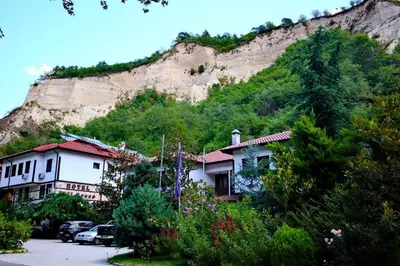 a mountain with houses and cars parked on a street at Хотел Свети Трифон in Melnik
