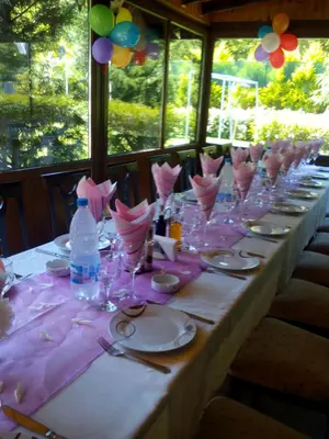 a long table with glasses and plates and a bottle of water at Хотел Свети Трифон in Melnik