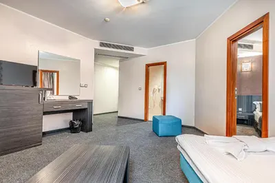 a bedroom with a bed and a desk and a mirror at Hotel Noris in Plovdiv