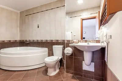 a bathroom with a tub and a toilet and a sink at Hotel Noris in Plovdiv