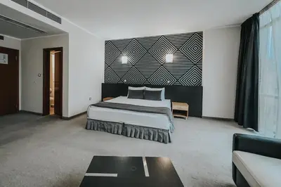 a bedroom with a large bed and a couch at Hotel Noris in Plovdiv
