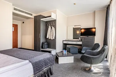 a hotel room with a bed and a desk at Hotel Noris in Plovdiv