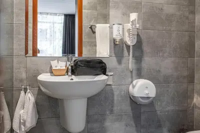a bathroom with a sink and a phone on the wall at Hotel Noris in Plovdiv