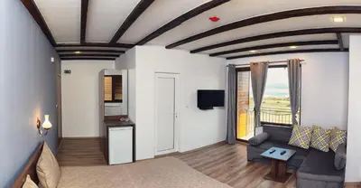 a living room with a couch and a window at Vila Lidia in Tsigov Chark