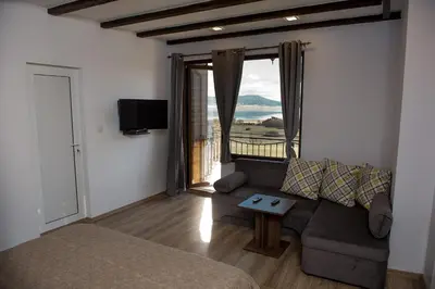 a living room with a couch and a large window at Vila Lidia in Tsigov Chark