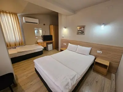 a bedroom with a large white bed and a television at Hotel Racic Self-Check In in Voyvodinovo