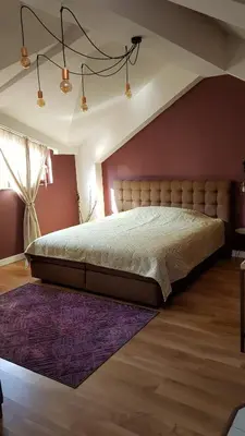 a bedroom with a large bed and a purple wall at Studio Maison 3 Kapana in Plovdiv