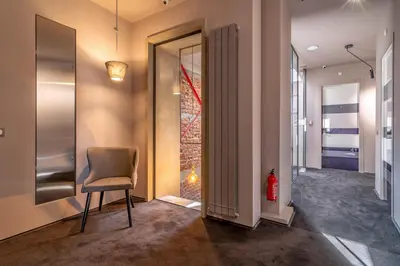 a hallway with a chair and a door with a fire extinguisher at Design Hotel 36 in Sofia