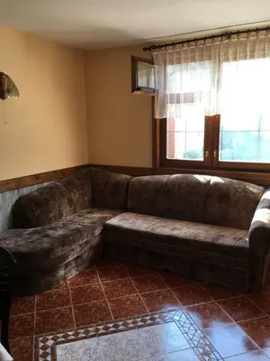 a large couch in a living room with a window at Villa Paradise in Beli Iskar