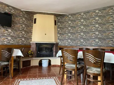 a dining room with a table and a fireplace at Villa Paradise in Beli Iskar