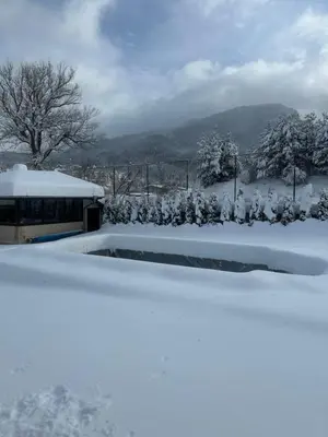 a bus is parked in a snow covered yard at Villa Paradise in Beli Iskar