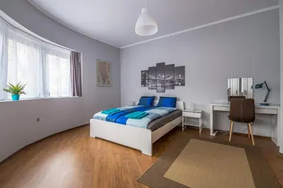 a bedroom with a bed with blue pillows and a desk at 5th Avenue Sofia Two Bedroom, Two Bathroom, Positano Street Suite by Flat Mаnager in Sofia