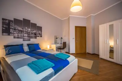 a bedroom with a large bed with blue pillows at 5th Avenue Sofia Two Bedroom, Two Bathroom, Positano Street Suite by Flat Mаnager in Sofia