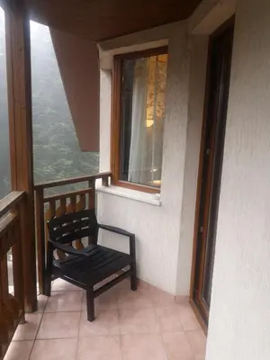 a black chair sitting on a balcony with a window at Snowdrop Studio in Borovets