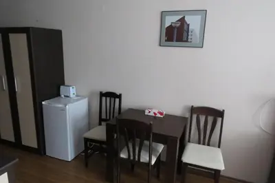 a dining room with a table and chairs and a refrigerator at Snowdrop Studio in Borovets