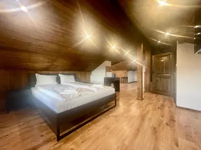 a bedroom with a large bed in a wooden ceiling at Къща за гости Алида in Sapareva Banya