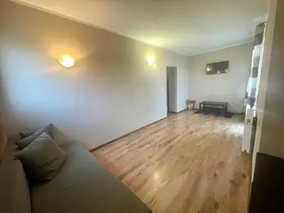 a living room with a couch and a wooden floor at Къща за гости Алида in Sapareva Banya