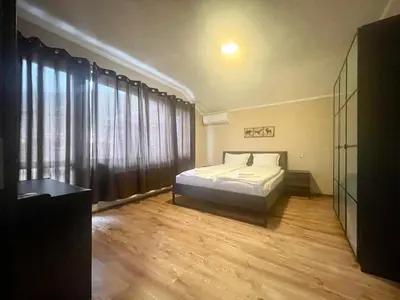 a bedroom with a bed and a large window at Къща за гости Алида in Sapareva Banya