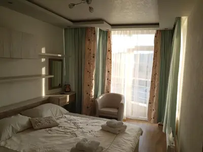 a bedroom with a bed and a chair and a window at Luxury Two Bedroom Flat in Blagoevgrad