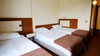a hotel room with two beds and a mirror at Nadejda Hotel in Sofia