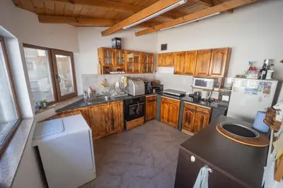 a kitchen with wooden cabinets and a white refrigerator at Banya Guest Rooms 23 in Banya
