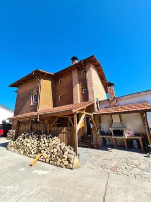 a house with a pile of logs in front of it at Villa Mura in Razlog