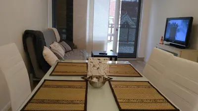 a living room with a table with three rugs on it at Modern apartment Sofia center in Sofia