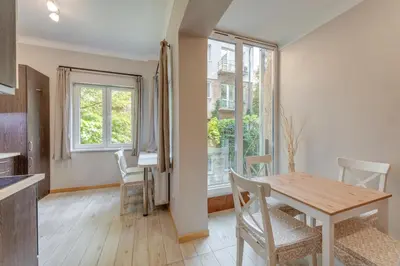 a kitchen and dining room with a table and chairs at Central Apartment in Sofia