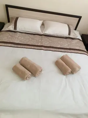 a bed with two brown pillows on top of it at Cosy Apartment - City Centre in Blagoevgrad