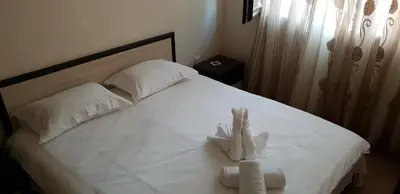 a stuffed animal is sitting on a bed at Cosy Apartment - City Centre in Blagoevgrad