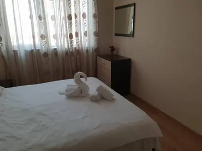 two swans sitting on top of a white bed at Cosy Apartment - City Centre in Blagoevgrad