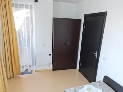 a bedroom with a door and a bed and a window at EFO Apartment in Bansko
