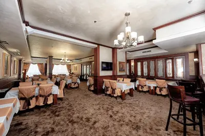 a dining room with tables and chairs and a chandelier at Platinum Image Hotel in Elin Pelin
