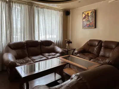 a living room with two leather couches and a glass table at Hotel Rai in Sofia