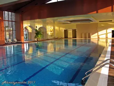 a large swimming pool in a building at Pravets Resort Apartments in Pravets