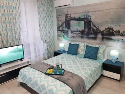 a bedroom with a bed and a flat screen tv at Best Guest Apartments in Plovdiv