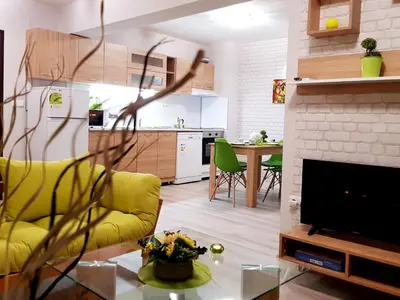a living room with a yellow couch and a fireplace at Best Guest Apartments in Plovdiv
